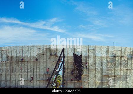 Builders on scaffolding at a construction site. Stock Photo