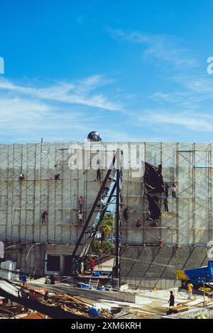 Builders on scaffolding at a construction site. Workers working. Stock Photo