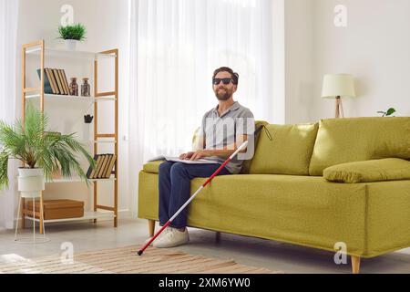 Blind Man Reading Braille Book On Sofa At Home Stock Photo