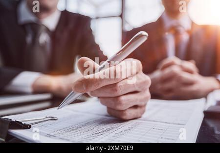 Close-up. Businessman looking at financial report and making notes with a pen in it Stock Photo