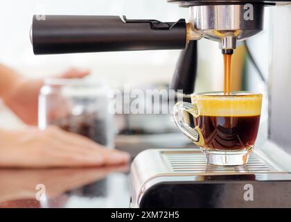 Espresso coffee machine in kitchen. Hot coffee pouring into cup Stock Photo