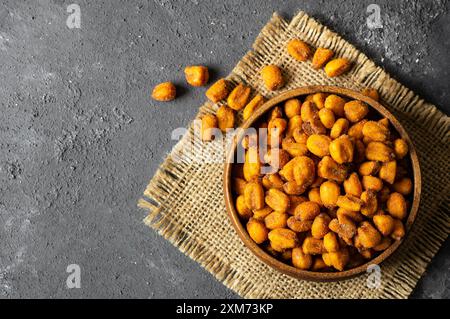 Roasted salted Corn Nuts with Spice and Sauce in bowl on rustic table, Nut concept Stock Photo