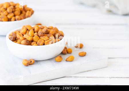 Roasted salted Corn Nuts with Spice and Sauce in bowl on rustic table, Nut concept Stock Photo