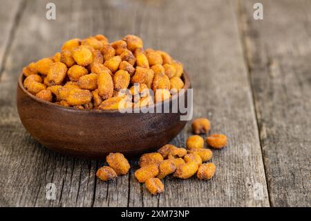 Roasted salted Corn Nuts with Spice and Sauce in bowl on rustic table, Nut concept Stock Photo