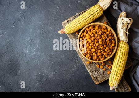 Roasted salted Corn Nuts with Spice and Sauce in bowl on rustic table, Nut concept Stock Photo