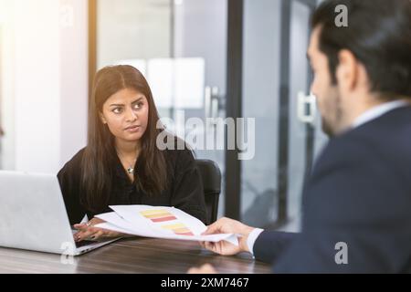 Indian business women talking with boss in office room, Marketing secretary work on the table with manager present information to deciding Stock Photo