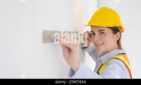 Beauty women construction worker model with Cement wall Plastering Tool looking camera happy smiling wide for advertising space Stock Photo