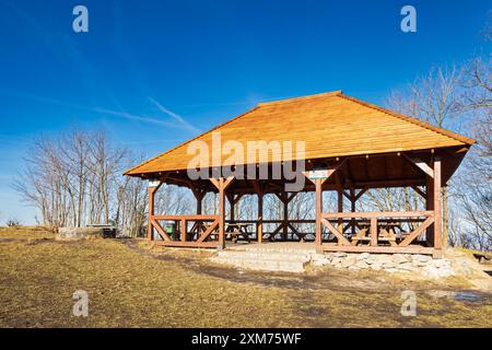 Sobotka, Poland - January 29 2024: Big wooden bower with wooden benches and tables inside on top of Sleza mountain at sunny day Stock Photo