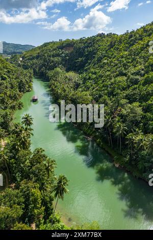 Aerial view of Loboc River and rainforest with tour boat, near Loboc, Bohol, Philippines Stock Photo