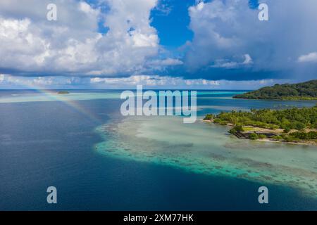 Aerial view of a rainbow on the reef near Marae Taputapuatea, Raiatea, Leeward Islands, French Polynesia, South Pacific Stock Photo