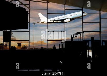 Air travel A plane taking off as passengers watch from the airport terminal Stock Photo