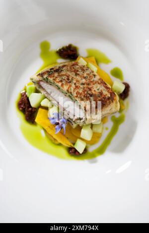 Pike-perch fillet in a herb crust on a bed of vegetables Stock Photo