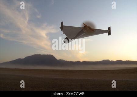 A military kamikaze drone flies over mountains in the desert against a backdrop of sky and clouds, war in Israel Stock Photo