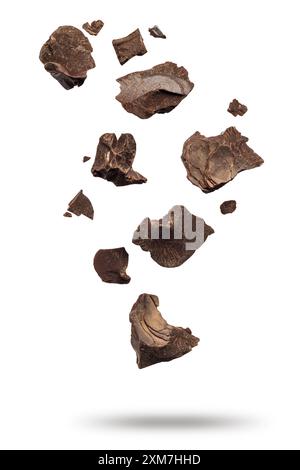 Dark chocolate flakes falling, isolated on white background. Stock Photo
