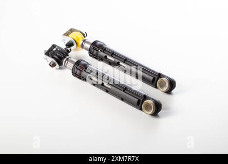 Shock absorbers dampening vibration of a washing machine on a white background, isolate, close-up. Stock Photo