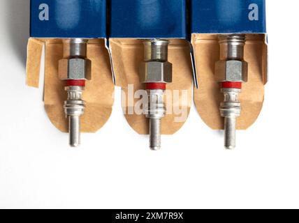 New modern ceramic glow plugs in packaging on a white background. Concept for replacing glow plugs in cold weather. Automotive part Stock Photo