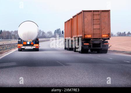 A truck with a semi-trailer tanker transports dangerous cargo along the highway - liquefied gas. Logistics of dangerous goods Stock Photo