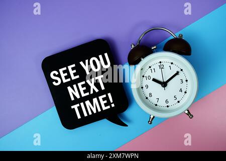 See You Next Time text on speech bubble with alarm clock top view on blue, purple and pink geometric background Stock Photo