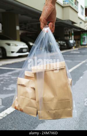 Hand holding a bag of food on the way home Stock Photo