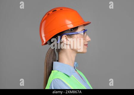 Engineer in hard hat and goggles on grey background Stock Photo