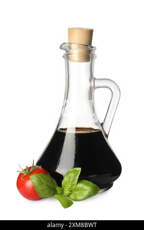 Balsamic vinegar in glass jug, tomato and basil isolated on white Stock Photo