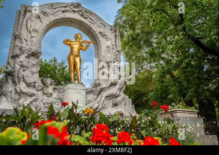 Vienna, Austria, August 22, 2022. A charming shot at the city park Stadtpark: the Strauss memorial with the golden statue, the marble arch and the flo Stock Photo