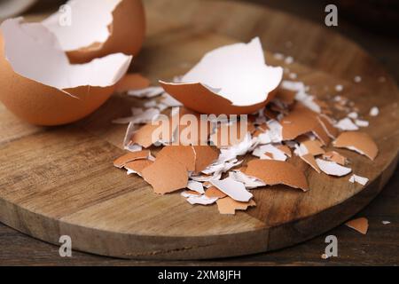 Pieces of broken eggshells on wooden table, closeup Stock Photo