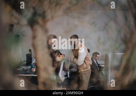 A diverse group of business people brainstorming and discussing marketing strategies for their successful startup in a creative office environment. Stock Photo
