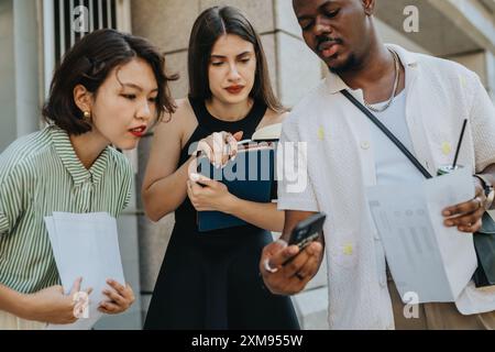 Diverse group of colleagues collaborating and discussing work outdoors Stock Photo