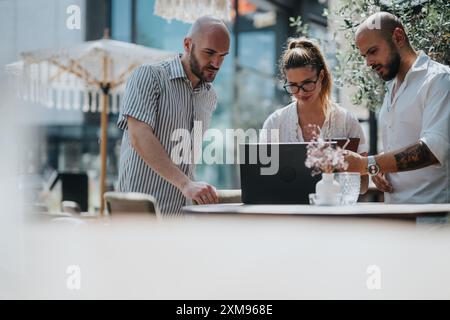 Business workers collaborating on a project in a coffee bar, brainstorming ideas and sharing knowledge while working remotely outdoors Stock Photo