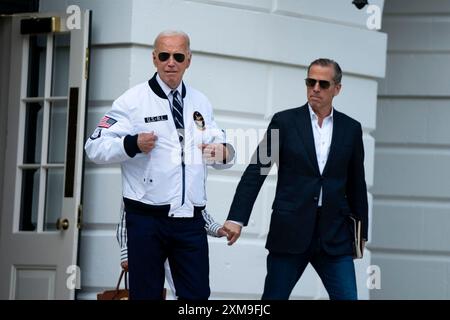 Washington, United States. 26th July, 2024. President Joe Biden gestures to his Team USA jacket as Hunter Biden looks on while exiting the White House to board Marine One en route to Camp David in Washington, DC on Friday, July 26, 2024. The 2024 Paris Olympics will take place from July 26 to August 11. Photo by Bonnie Cash/UPI Credit: UPI/Alamy Live News Stock Photo