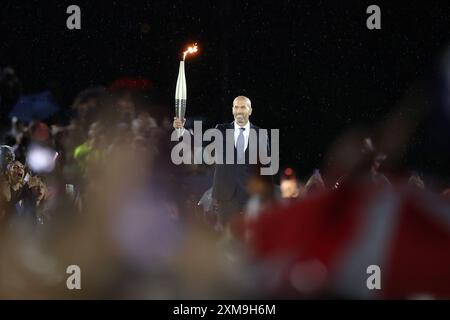 (240726) -- PARIS, July 26, 2024 (Xinhua) -- Former French Footballer Zinedine Zidane holds the torch during the opening ceremony of the Olympic Games Paris 2024 at Place du Trocadero on July 26, 2024 in Paris, France. (Cameron Spencer/Getty Images/Pool via Xinhua) Stock Photo