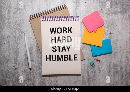 WORK HARD STAY HUMBLE text concept write on a notebook on wooden background Stock Photo