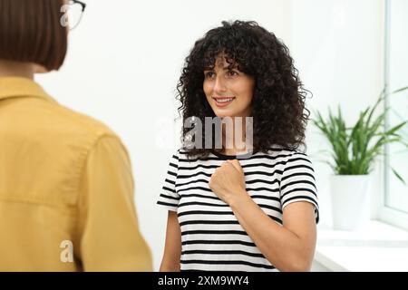 Young women using sign language for communication indoors Stock Photo