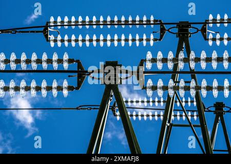 Insulators made of glass on a high-voltage line, they hang on the pylons as a suspension device between the pylon and the live, non-insulated cable Stock Photo