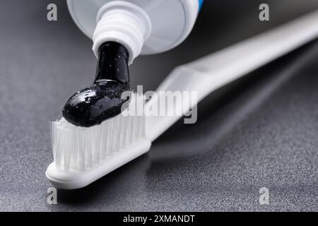 Black charcoal whitening toothpaste being squeezed from tube Stock Photo