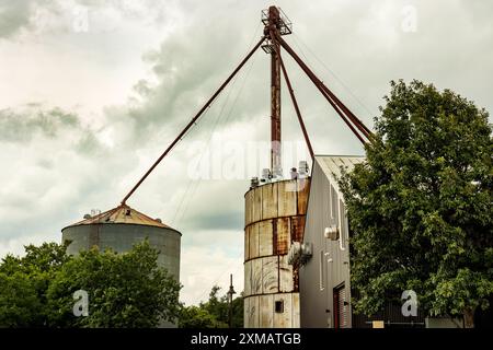 Historic Buda, TX mill with corrugated metal grain silo, rusty metal framework.  Rustic charm and blend of agriculture and industrial architecture. Stock Photo