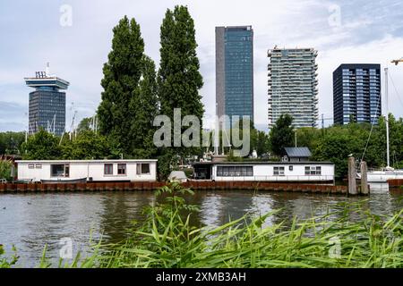 Houseboats at Sixhaven, on the river Ij, behind them high-rise buildings in the Overhoeks neighbourhood, Amsterdam, Netherlands Stock Photo