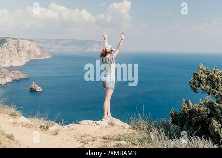 Woman Celebrating on a Clifftop with a Sea View Stock Photo