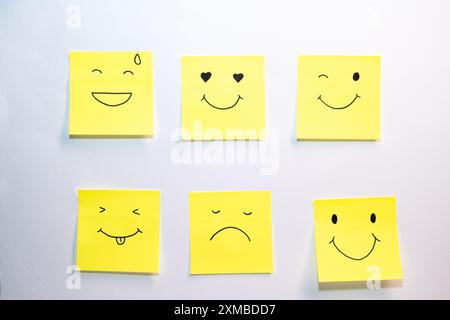 A collection of yellow sticky notes with different facial expressions. Scene is lighthearted and cheerful Stock Photo