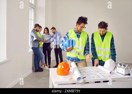 Engineers and architects discussing for plans for new home and working on a building site Stock Photo