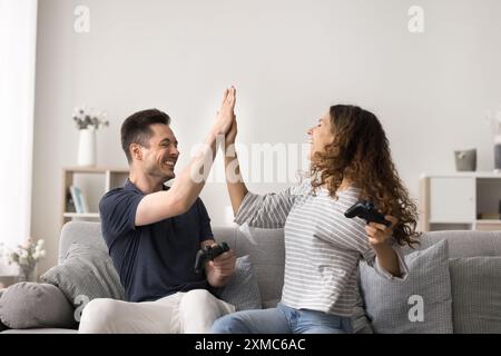 Cheerful Hispanic couple celebrate victory at console game Stock Photo