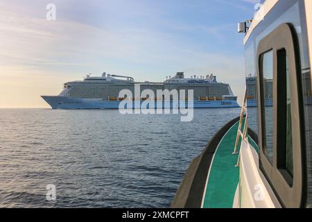 Nice, France : Harbor pilot boat approaching the giant Royal Caribbean's ANTHEM OF THE SEAS to embark the maritime pilot in Villefranche sur Mer. A unique stopover for the largest cruise ship this year in the French Riviera's small port. After summer season, the impressive ship was to sail through Suez Canal as part of a repositioning from Europe to new homeport in Singapore but following Red Sea tensions & Houthi missile attacks threats on ships, she will instead transit without passenger around the southern tip of Africa to reach Dubai & Asia.Credit: Kevin Izorce/Ģ����ý Live News Stock Photo