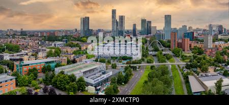 Manchester Metropolitan University campus and buildings with the Manchester skyline in the background at sunset Stock Photo