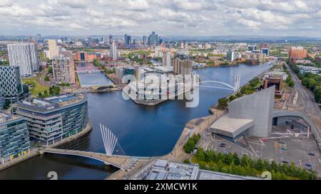 Salford Quays, Manchester waterfront, with the Imperial War Museum, BBC Studios and the Lowry. Skyline of Manchester and Old Trafford. Aerial view Stock Photo