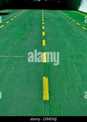 An empty deck with green and yellow markings for cars on a shipping ferry, Norway, Hardangerfjord. Stock Photo