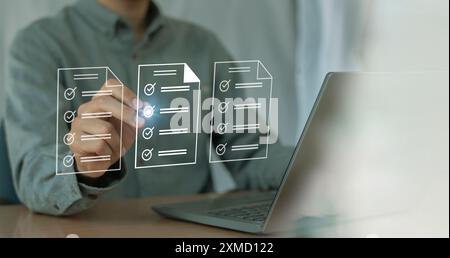 Businessman checks digital checklist documents in hand technology about paperless digital document operation, document control and management concept. Stock Photo