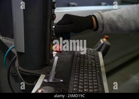 Master works on a special machine using a control panel Stock Photo