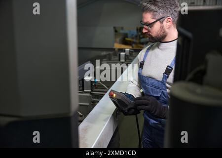 Employee in work gear at a workplace in production workshop Stock Photo