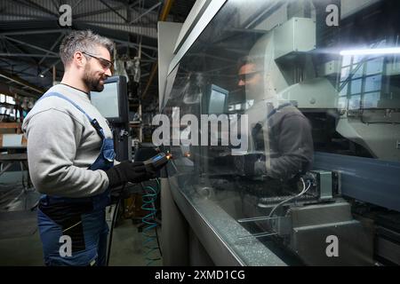 Professional uses a control panel to work on modern equipment Stock Photo